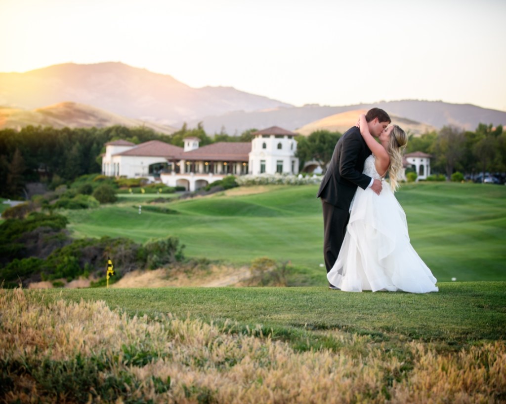 groom kissing bride on the course